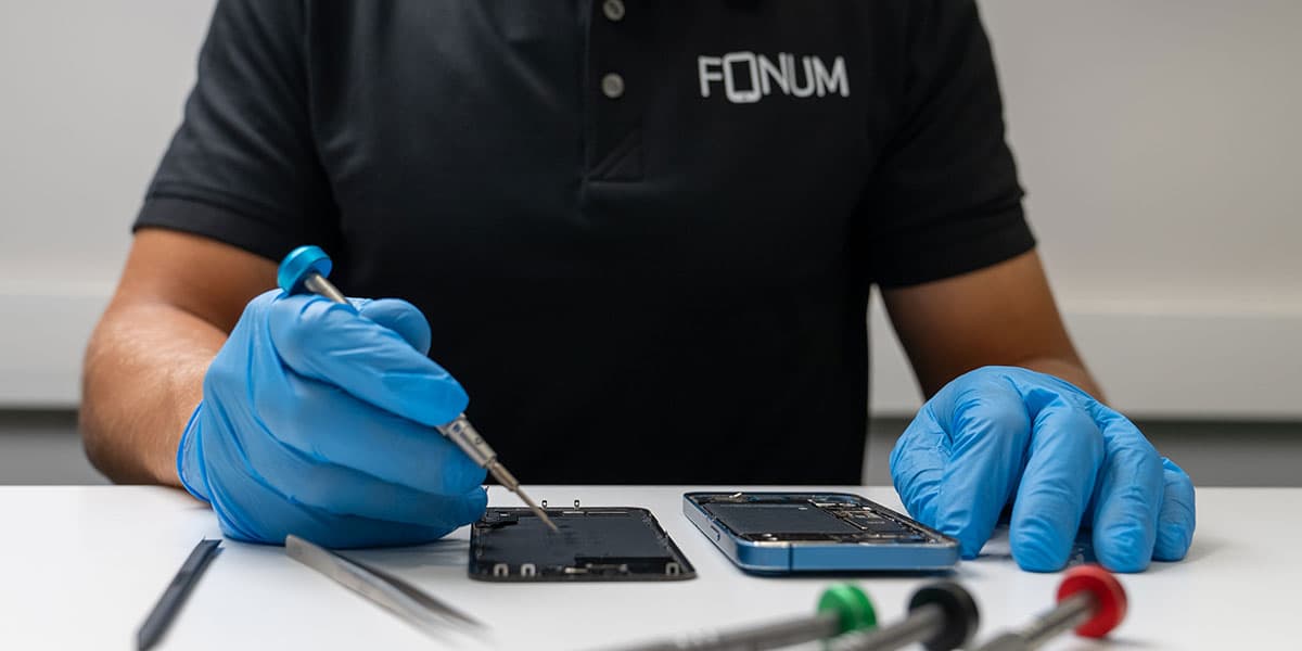 Fonum asiantuntija korjaa puhelinta